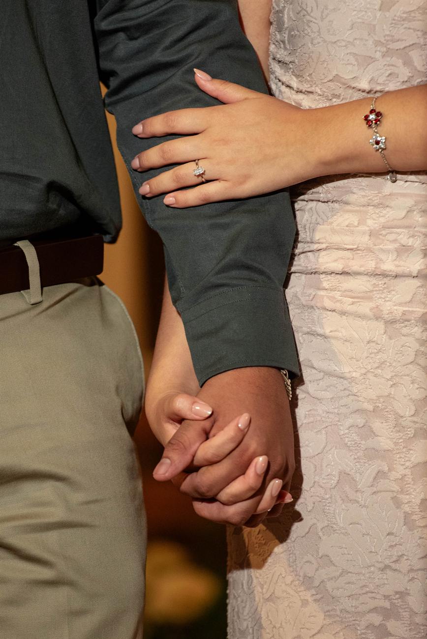 Las manos de Iván y Angie entrelazadas; ella lleva el anillo.