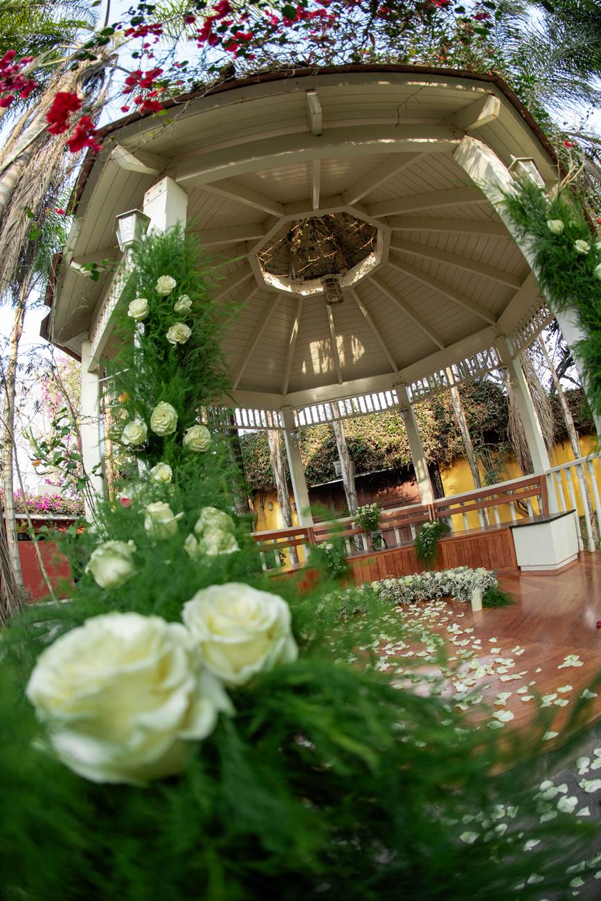 La glorieta decorada con rosas blancas y pétalos en el piso.