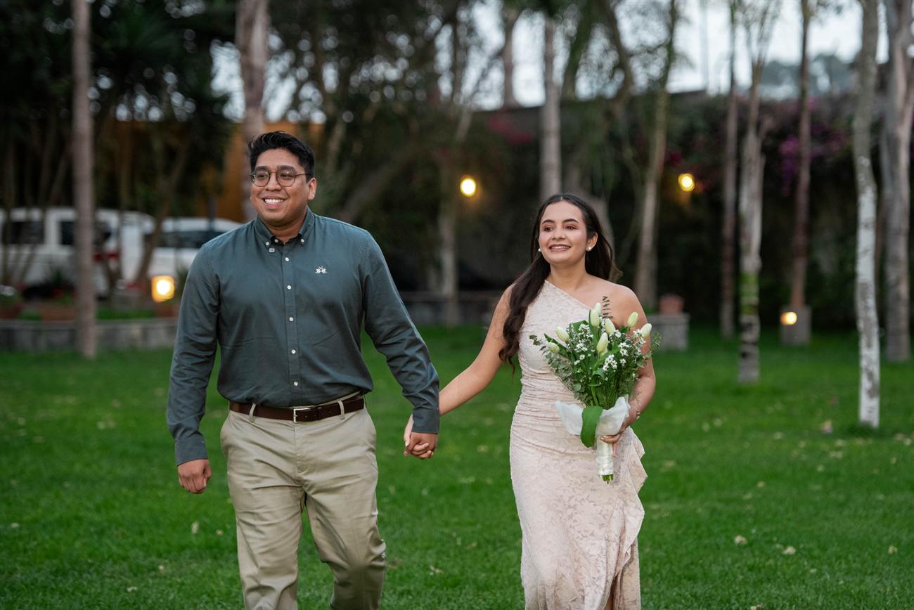 Iván y Angie caminan por el jardín al atardecer.