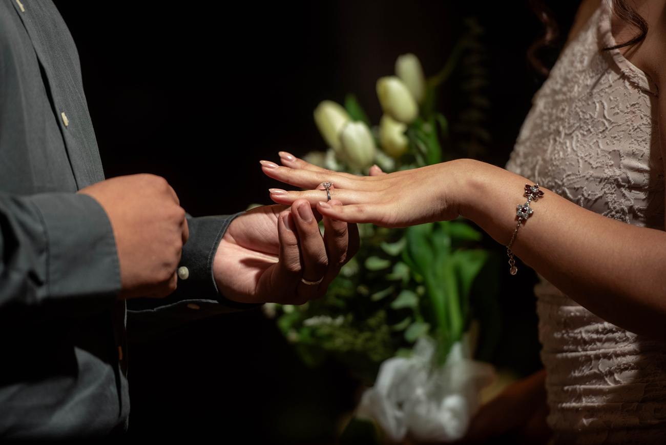 Primer plano: Iván coloca el anillo de compromiso en la mano de Angie.